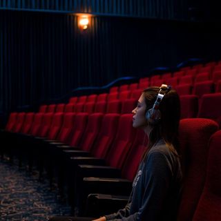 Siedzenie, słuchanie muzyki (nie mówienie lub czytanie) lub oglądanie filmu w kinie