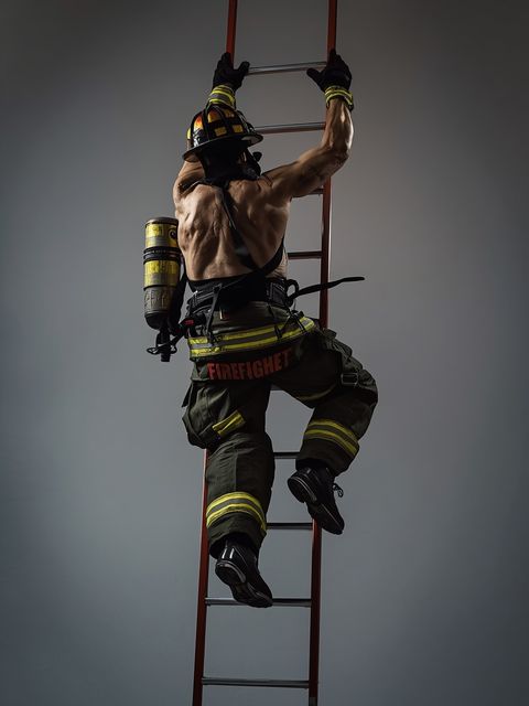 Feuerwehrleute, Auf- und Kletterleiter mit vollständiger Ausrüstung, simulierte Feuerbekämpfung