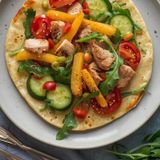 Tortilla mit gebratenem Truthahn, Rucola, Tomate, Gewürzgurke und Paprika kalt serviert